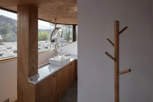 Minimalist bathroom featuring a white sink and wooden elements with a scenic view from the window.