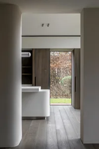 A modern residential entryway featuring wood and concrete materials, with minimalist design elements.