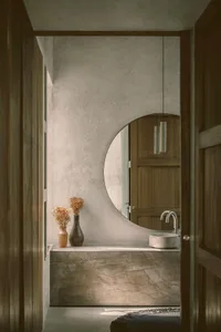 A minimalist bathroom features concrete materials, emphasizing simplicity and functionality in a modern design.