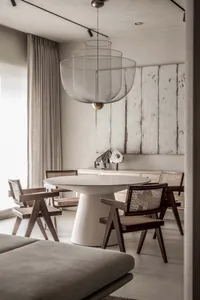 Modern minimalist dining room featuring a metal mesh pendant light fixture.
