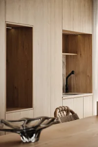 Modern minimalist kitchen with wood cabinets and a sleek sink.