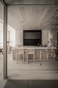 Modern minimalist residential kitchen featuring light-colored wooden cabinets and flooring.