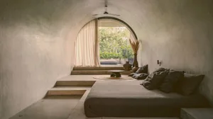 Modern concrete bedroom with a minimalist design and natural light.