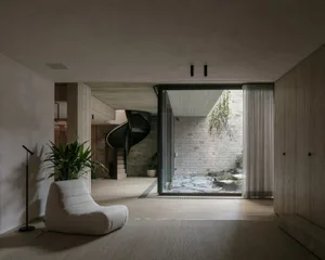 A modern living room featuring wooden flooring, minimalist furniture, and contemporary decor.