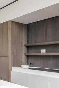 A modern residential kitchen featuring wooden cabinets and a stone countertop.