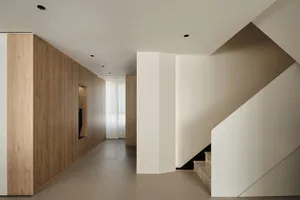 Modern staircase with wooden walls and concrete steps in a minimalist interior design.