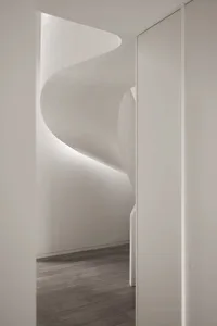 White concrete spiral staircase with minimalist design and soft lighting.