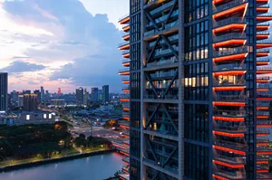 Modern cityscape featuring a glass skyscraper during dusk.