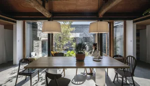 Contemporary dining room featuring a wooden table, glass pendant lights, and minimalist design elements.