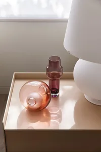 Modern side table with glass vessels and a white lamp。