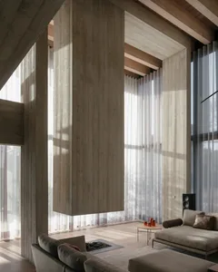 Minimalist living room featuring wood, concrete, and transparent textiles.