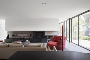 A modern living room featuring concrete and glass elements with a sleek, minimalist design.