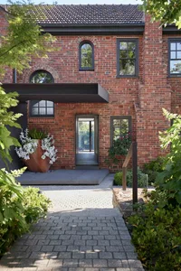 A modern residential entrance featuring brick walls and glass windows.