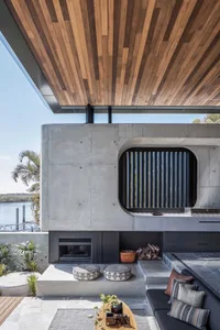 An industrial-style outdoor living area with a fireplace and barbecue grill.