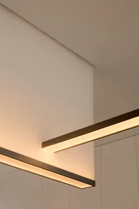 Modern, minimalist interior design featuring sleek, metallic lighting fixtures.