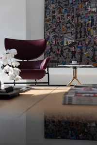 Modern living room with a marble table and purple armchair, featuring intricate mural art.