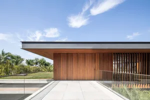 A modern minimalist exterior with wooden panels and a glass railing.