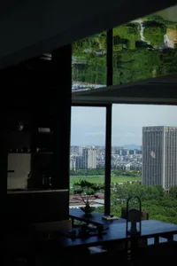 A modern office interior with a sleek glass window offering a scenic view of the city.