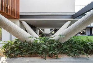 Modular, contemporary residential exterior with concrete columns supporting the upper floor.