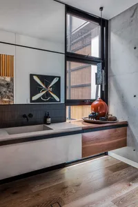 Modern bathroom featuring concrete sink and wood accents, with a large window and minimalist design.
