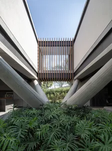 A modern exterior architectural design featuring concrete materials with a clear blue sky in the background.