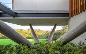 Modern exterior featuring concrete columns and a hillside background