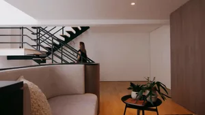A modern residential living space featuring white concrete and steel materials, with a minimalist design aesthetic.