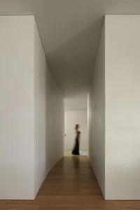 A minimalist hallway with concrete walls and wooden flooring