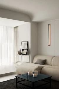 Modern minimalist living room with textured fabric sofa, metal side table, glass vase, and wooden coffee table.