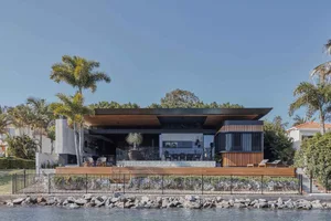 A modern waterfront residence featuring concrete and wooden elements