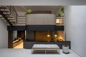 Modern minimalist living room with concrete elements and plants.