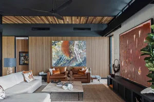 A modern living room featuring wooden walls, a metallic coffee table, and leather furniture.