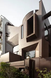 A modern building exterior constructed with concrete, featuring geometric shapes and large windows.