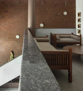 Modern industrial lounge space with wooden furniture, concrete walls, and textile upholstery.