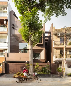 Tree trunk surrounded by modern buildings, street vendor with cart, and residential neighborhood.