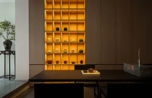 Well-lit wooden shelves displaying various ceramic vases and pots, situated in a modern tea house setting.