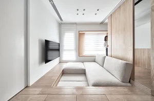 A minimalist living room with neutral textiles and a modern sofa.
