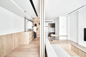 A minimalist residential interior with white walls and wooden elements.