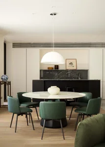 A modern living room with a wooden pendant light hanging from the ceiling.