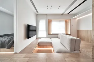 Modern living room interior with a built-in platform, wooden floor, and furniture.