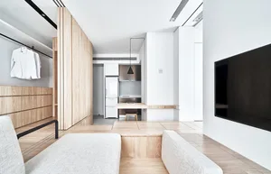 Modern minimalist apartment featuring a white wood floor, white walls, and white minimalist furniture, with a white refrigera