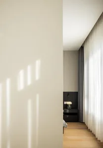 Contemporary minimalist bedroom featuring a sleek design with white and grey tones.