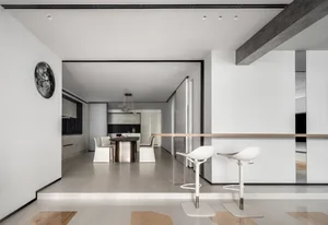 A modern minimalist kitchen with metal accents, glass elements, and concrete flooring.