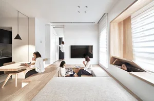 Group of women enjoying coffee in a modern minimalist residential setting with wooden furniture and white walls.