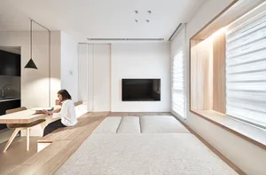 A modern residential interior featuring minimalist design, wood flooring, and laminate surfaces.