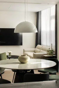 Modern living room with a marble table and white sofa, featuring contemporary furniture and minimalist design.