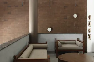 Minimalist interior design featuring wooden furniture and fabric seating.