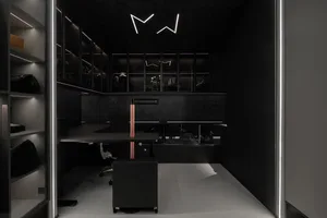 A sleek, modern office space featuring metallic black storage cabinets and a desk with a unique central column.