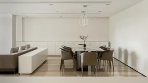 Modern dining room with a marble table, leather chairs, and wooden flooring.