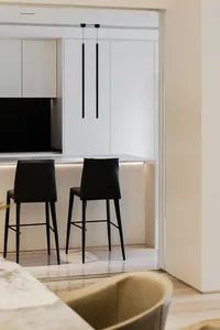 A modern minimalist kitchen with black and white color scheme and sleek cabinetry.